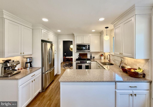 kitchen featuring a sink, appliances with stainless steel finishes, white cabinets, and light wood finished floors