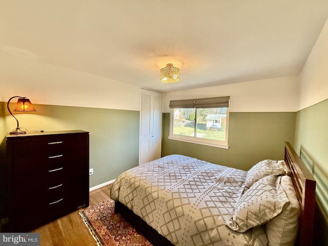 bedroom featuring wood finished floors, baseboards, and a closet