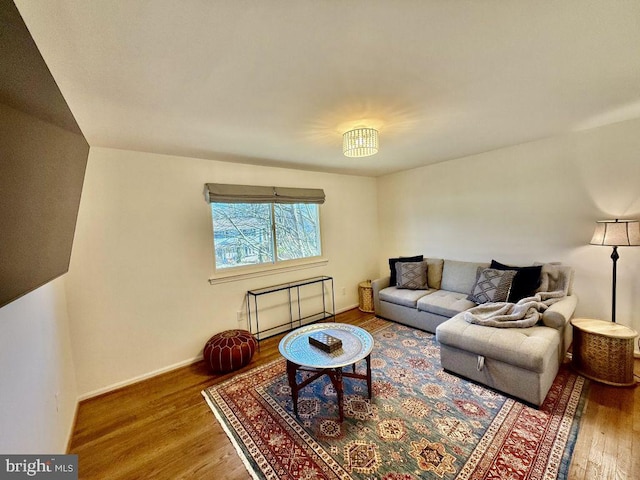 living area featuring baseboards and wood finished floors