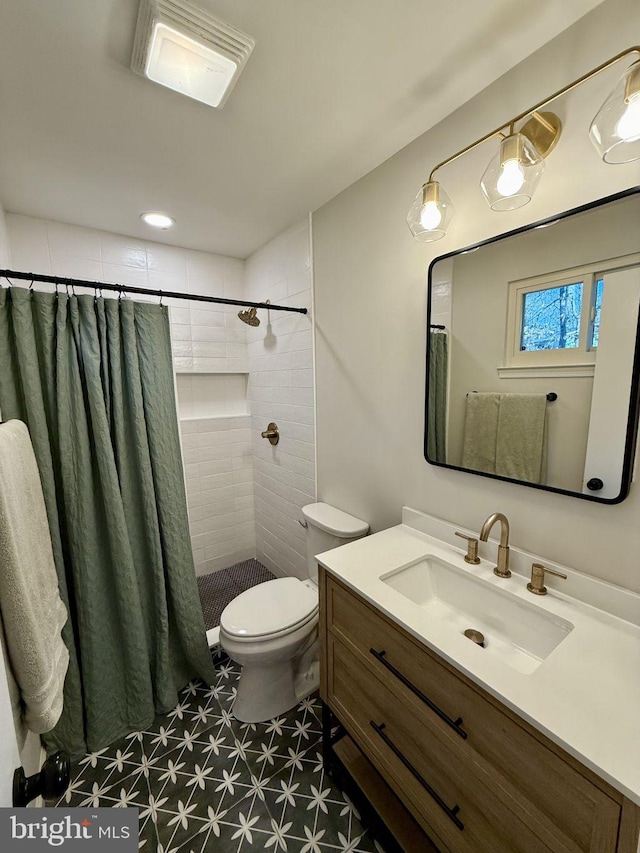 full bath with vanity, toilet, visible vents, and a tile shower