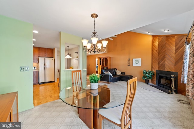 dining room with recessed lighting, a large fireplace, and a notable chandelier