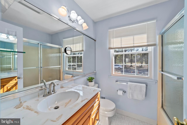 full bath featuring an enclosed shower, baseboards, a healthy amount of sunlight, and vanity