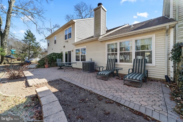 back of property featuring a patio, central AC unit, and a chimney