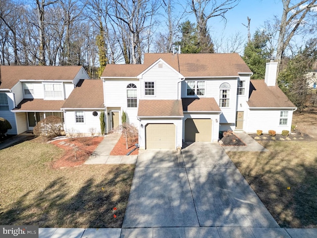 view of front of house featuring an attached garage, concrete driveway, a front lawn, and roof with shingles