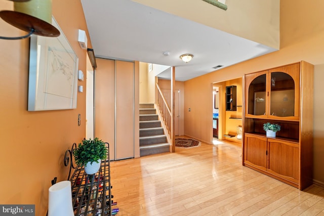 interior space with elevator, wood finished floors, visible vents, and baseboards