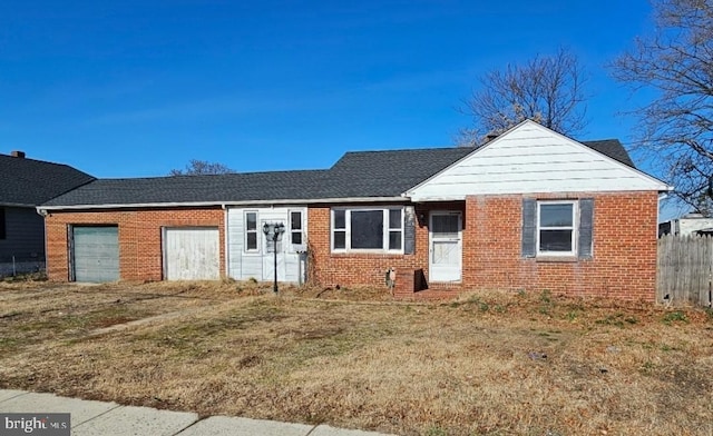 ranch-style home featuring brick siding, an attached garage, a shingled roof, and fence