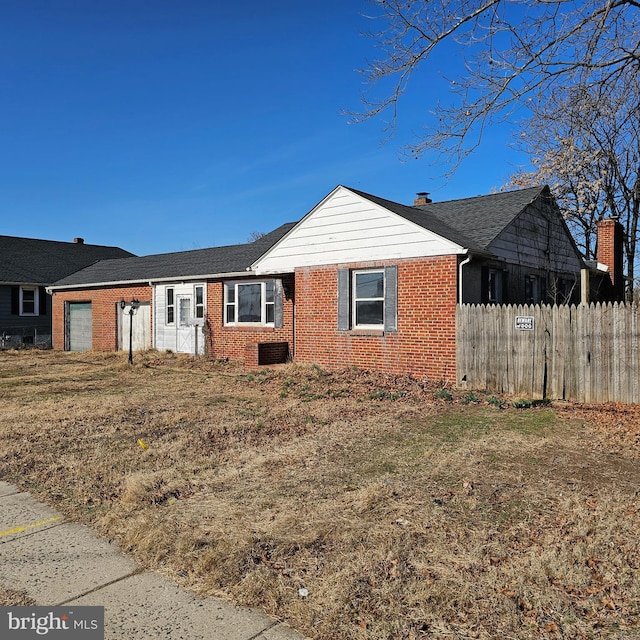 ranch-style house featuring an attached garage, fence, and brick siding