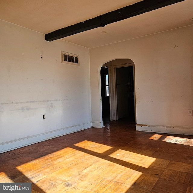 spare room with visible vents, arched walkways, and beamed ceiling