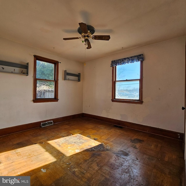 unfurnished room featuring visible vents, a healthy amount of sunlight, and baseboards