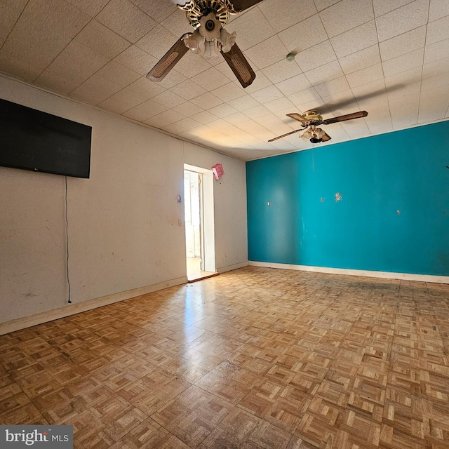 unfurnished room with baseboards and ceiling fan