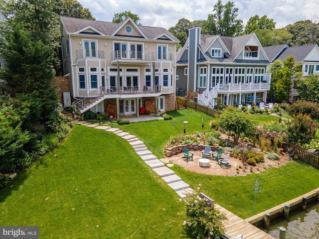 back of property with a patio, french doors, a yard, a fire pit, and a balcony