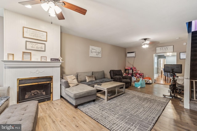 3144 Gaul St, Philadelphia, PA 19134 - living area with a wall mounted AC, a fireplace, wood finished floors, and a ceiling fan