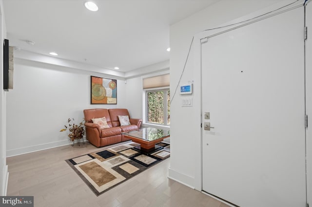 living room featuring recessed lighting, light wood-type flooring, and baseboards