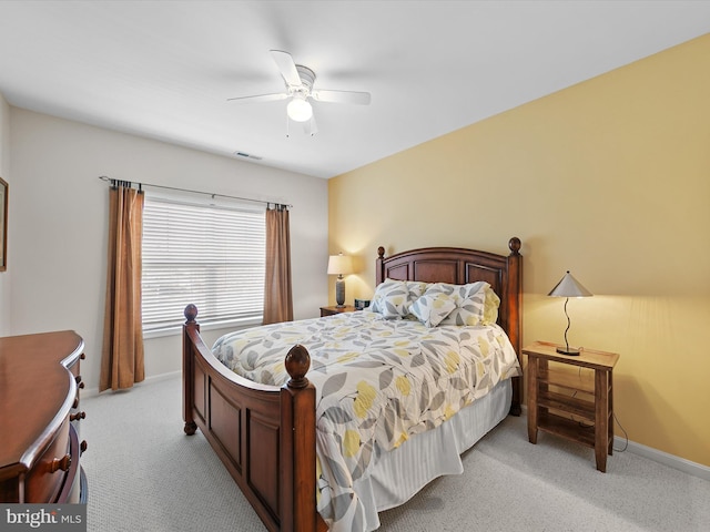 bedroom featuring ceiling fan, light colored carpet, visible vents, and baseboards