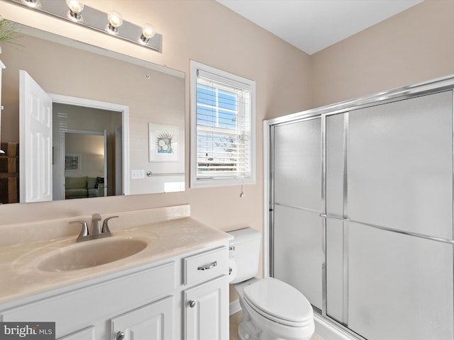 ensuite bathroom with vanity, a shower stall, toilet, and connected bathroom