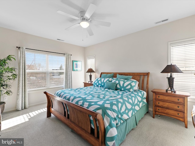 bedroom with a ceiling fan, light colored carpet, and visible vents