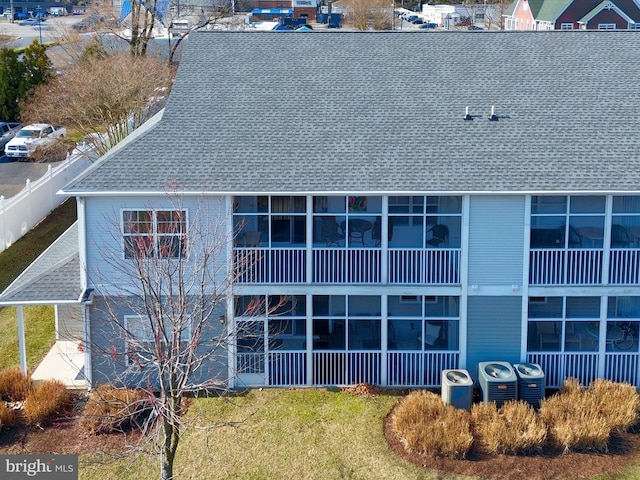 view of building exterior with central air condition unit and fence