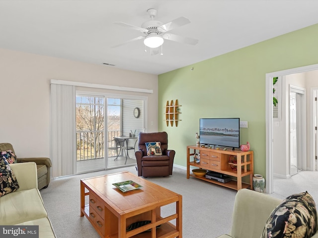 carpeted living area with visible vents, baseboards, and ceiling fan