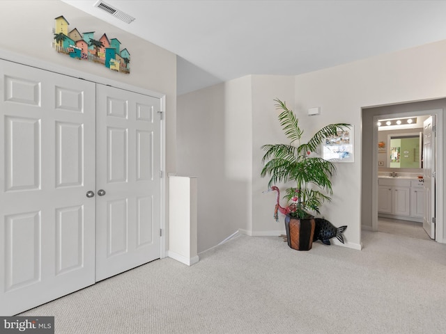 interior space with a closet, visible vents, ensuite bathroom, and baseboards