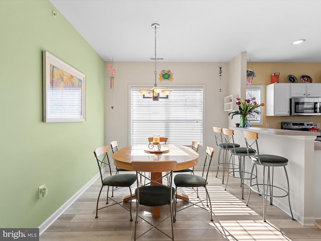 dining area with baseboards and light wood-style floors