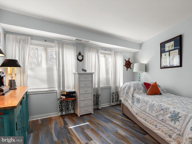 bedroom featuring dark wood finished floors, visible vents, multiple windows, and baseboards