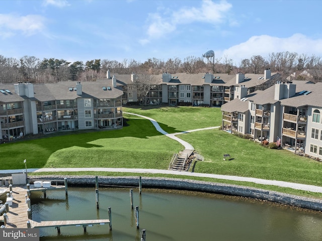 exterior space featuring a residential view, a yard, and a water view