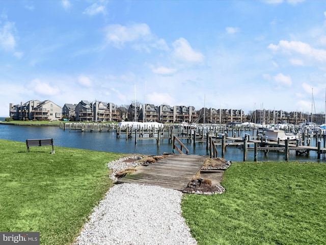 view of dock featuring a water view and a lawn