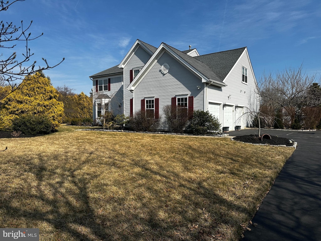 view of front facade featuring driveway, a front lawn, and a garage