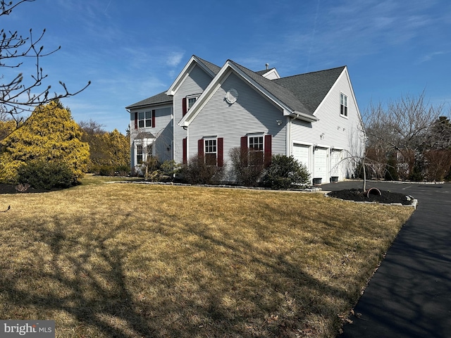 view of front facade featuring driveway, a front lawn, and a garage