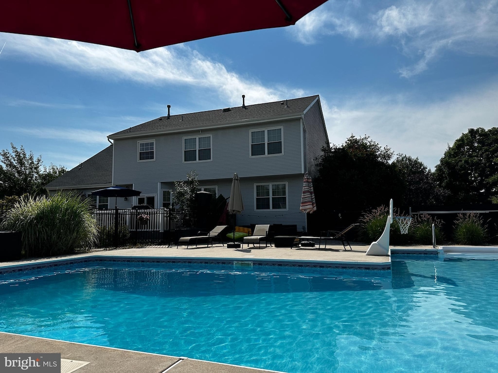 view of swimming pool featuring a patio area, a fenced in pool, and fence