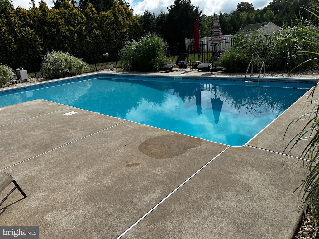 view of swimming pool featuring a fenced in pool, a patio, and fence