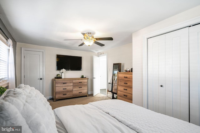 bedroom featuring a closet, light carpet, baseboards, and a ceiling fan