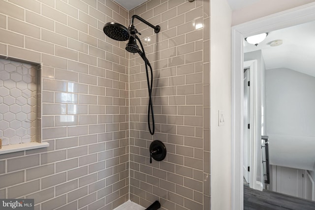 full bathroom with tiled shower and vaulted ceiling