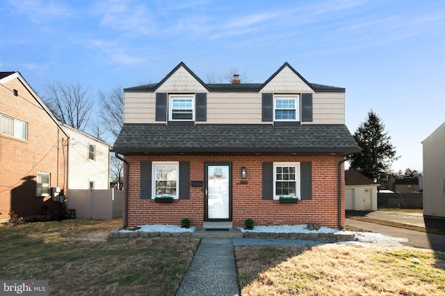 view of front of property with brick siding, a shingled roof, and fence