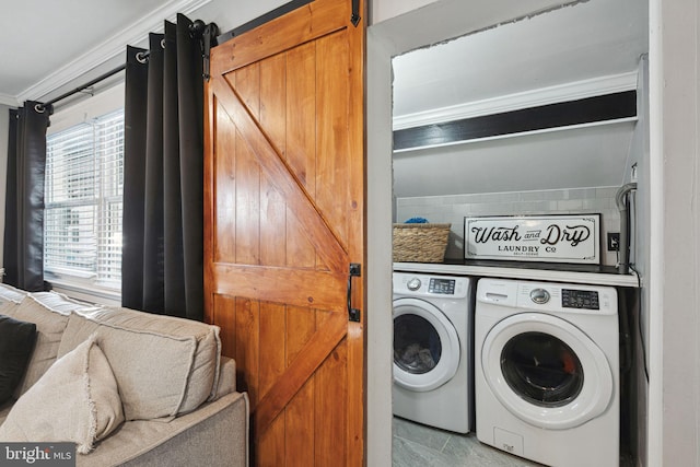 laundry area featuring a barn door, ornamental molding, independent washer and dryer, and laundry area