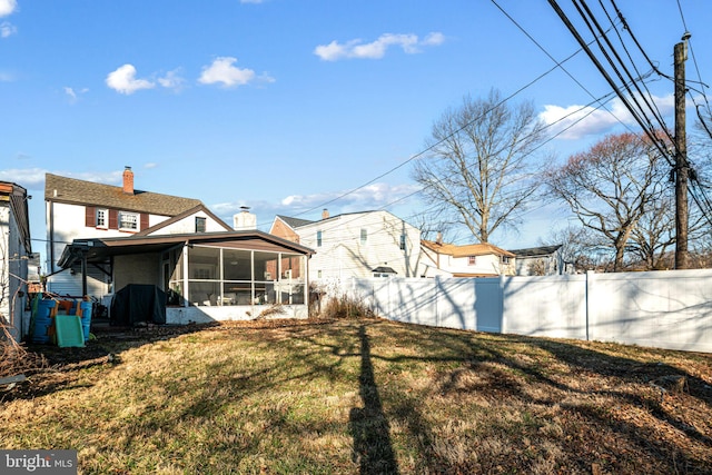 view of yard with fence and a sunroom