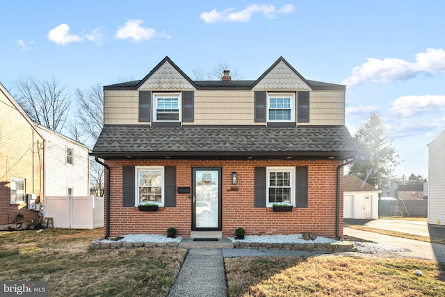 view of front of house with fence, brick siding, and a shingled roof