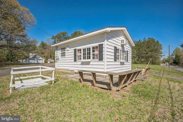 view of side of home featuring a yard and an outdoor structure