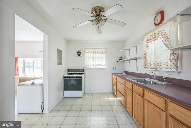kitchen featuring open shelves, a sink, white gas stove, and plenty of natural light