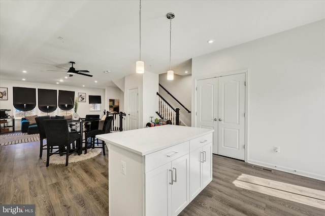 kitchen featuring a kitchen island, recessed lighting, wood finished floors, hanging light fixtures, and white cabinets