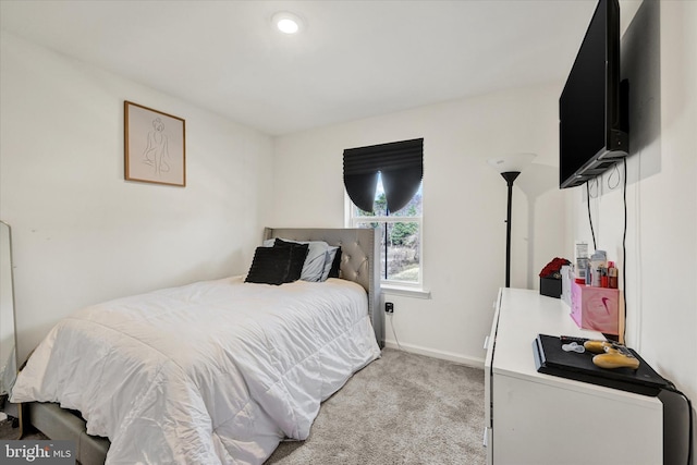 bedroom with baseboards and light carpet