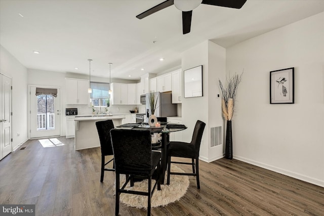 dining room featuring dark wood finished floors, visible vents, and baseboards