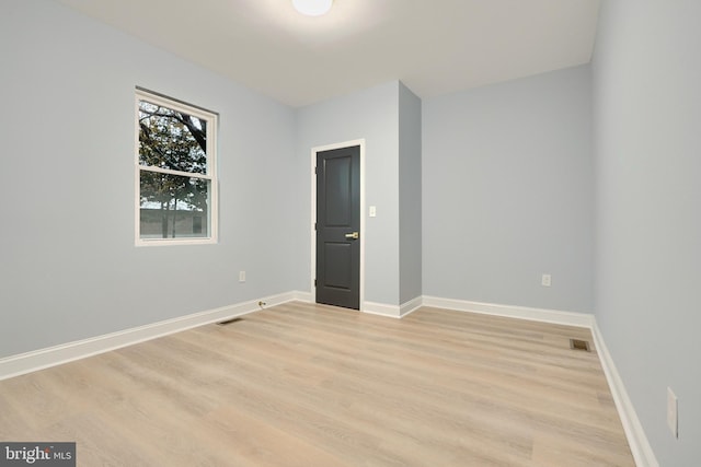 empty room featuring visible vents, baseboards, and light wood-style floors