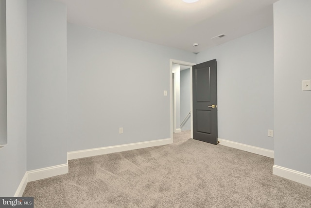 spare room with visible vents, carpet, and baseboards