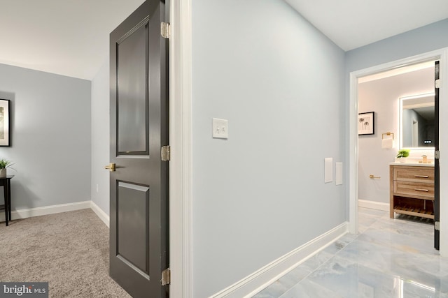 hall with light colored carpet and baseboards