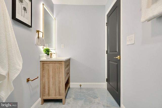 bathroom with vanity, baseboards, and marble finish floor