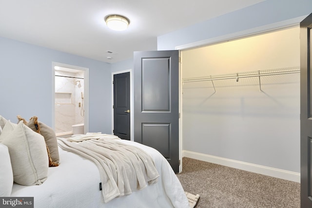 bedroom featuring a closet, ensuite bathroom, baseboards, and carpet floors