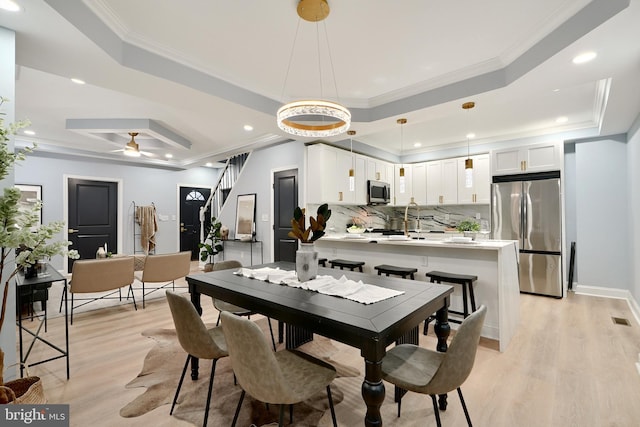 dining space with stairs, a tray ceiling, and crown molding