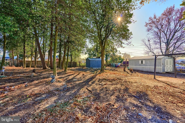 view of yard with a storage unit, an outdoor structure, and fence