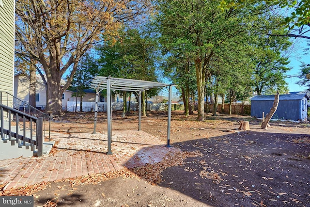 view of yard featuring fence, a shed, a patio area, an outbuilding, and a pergola